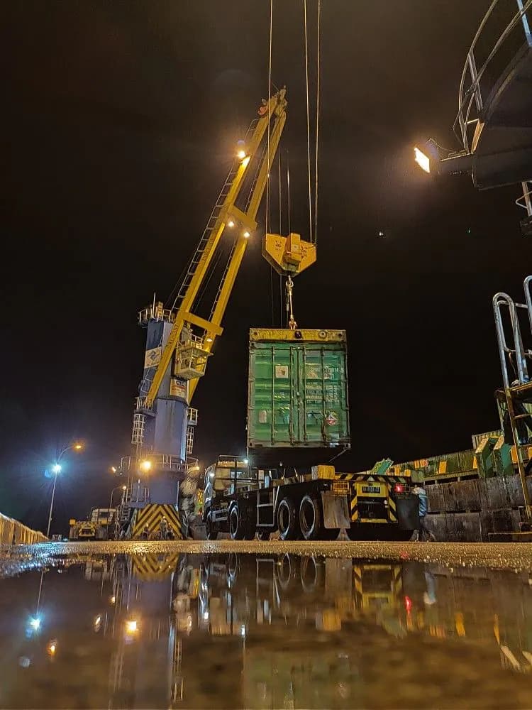 Container lifted at an international cargo terminal during night operations