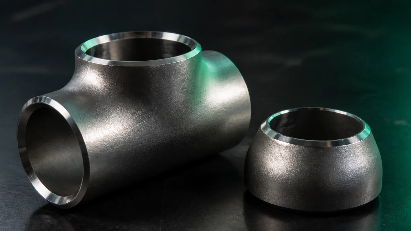 Illustrative Monel 400 equal tee and pipe cap fittings